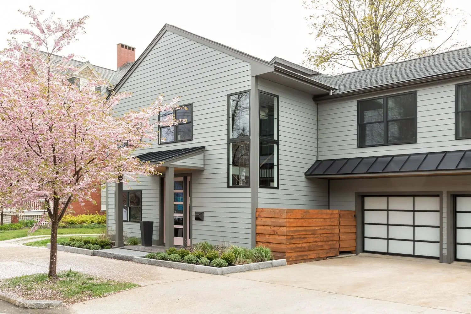 Renovated home exterior with gray siding and flowering cherry tree – Vaughan Street project, Portland, Maine, near Falmouth