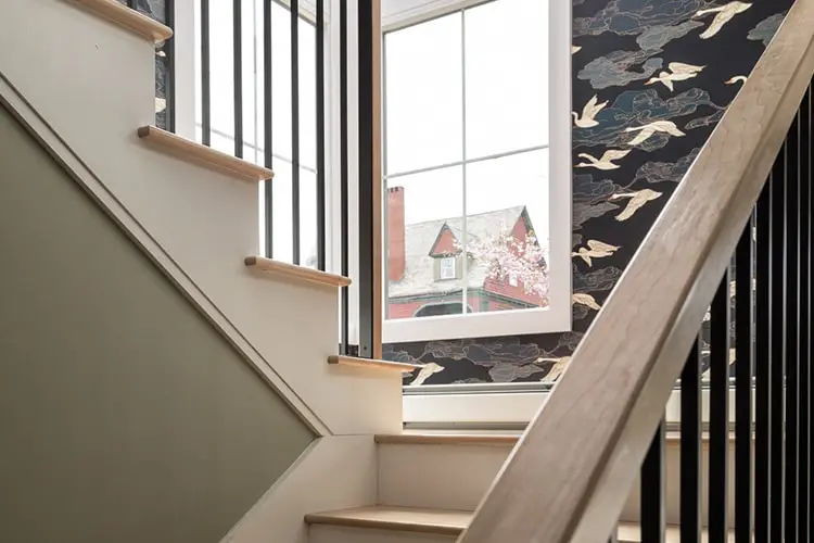 Stairway with wallpaper and black rail – Vaughan Street renovation, Portland, Maine